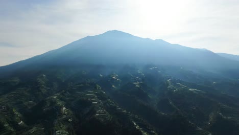 mysterious morning mist over wonolelo village on mount merbabu slope, indonesia, aerial view