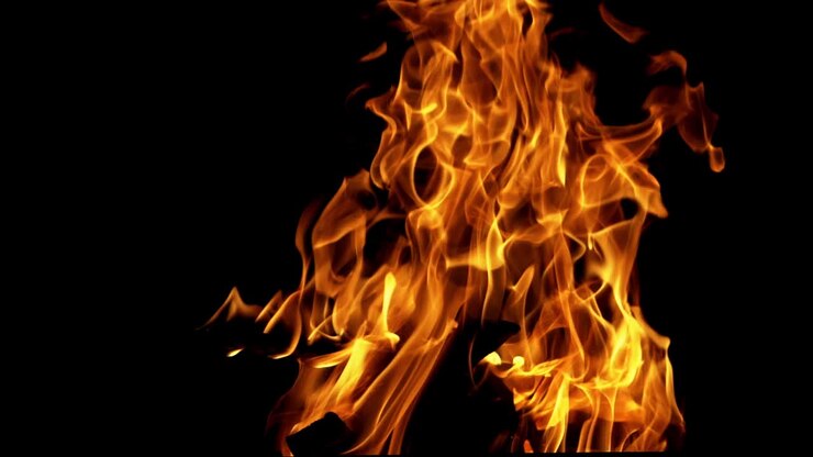 Legna ardente e luminosa in slow motion. Fiamma di fuoco. Falò.