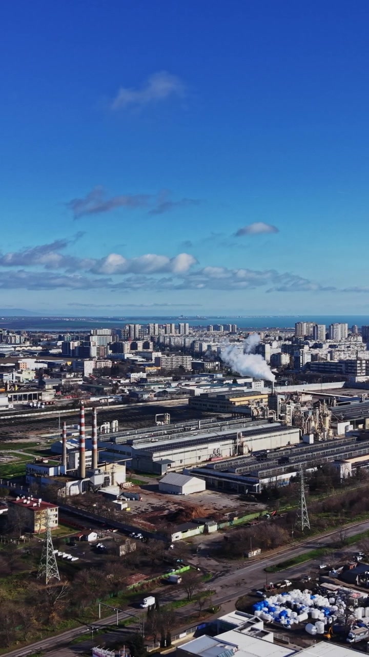 Paisaje urbano que muestra una zona industrial y edificios bajo un cielo despejado