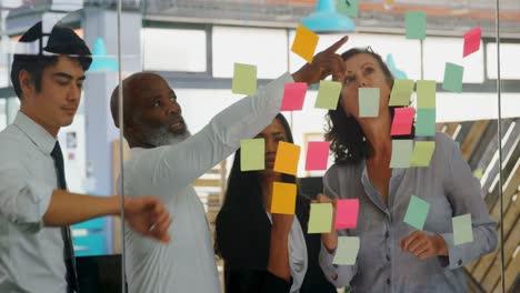 executives discussing over sticky note on glass wall 4k