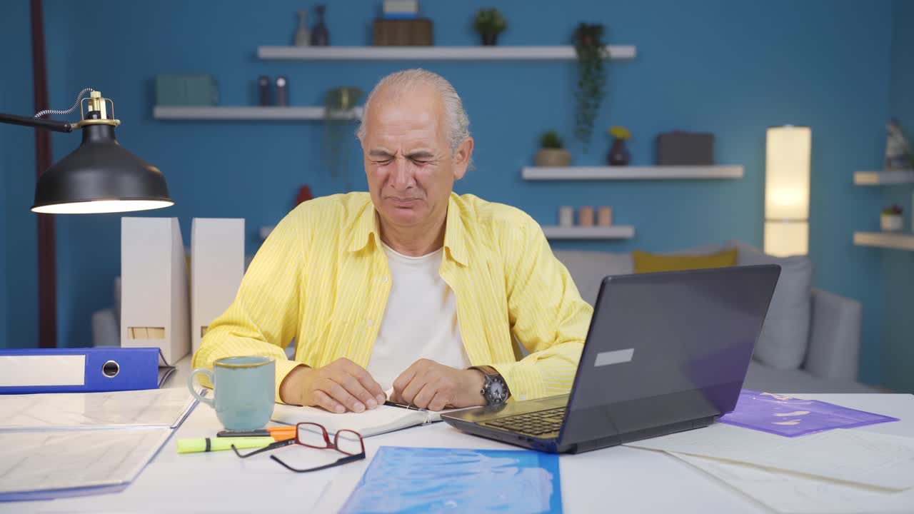 Home office worker old man looking at camera with disgust and hatred.