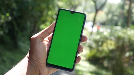 Rear-view-of-young-man-using-smart-phone-at-outdoor