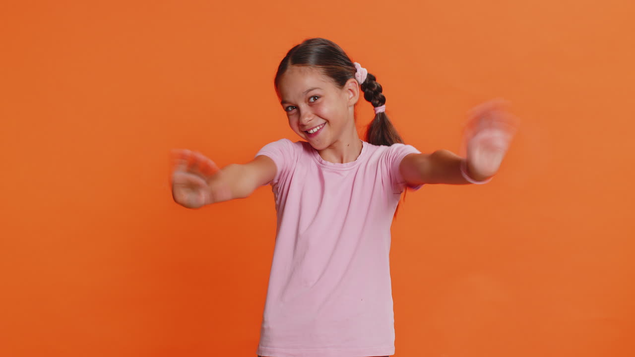 Young cute school girl kid smiling friendly gesturing hello or goodbye welcoming waving hands