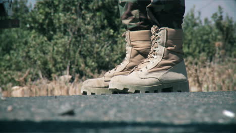 An-army-soldier-holds-a-gun-in-his-hand-military-boot