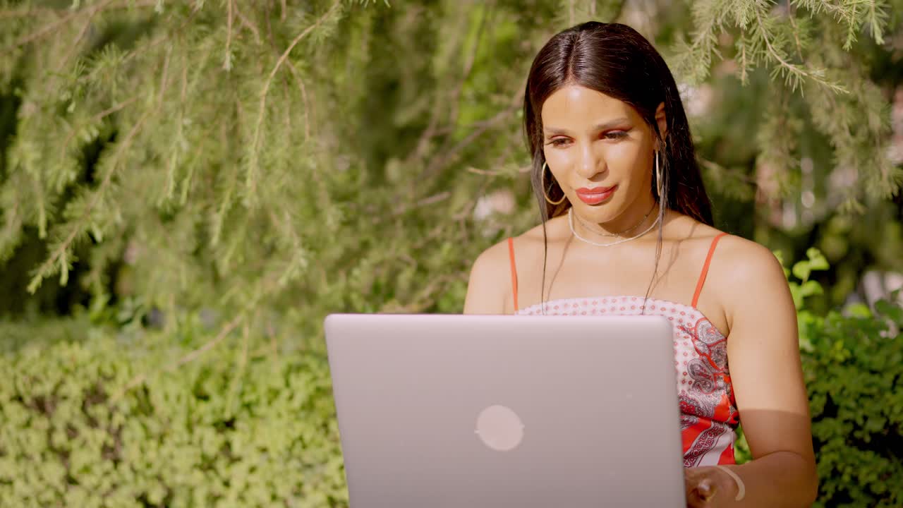 Woman Using Laptop Outdoors in a Sunny Park