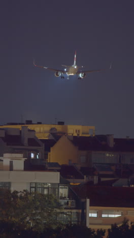 airplane landing at night over city