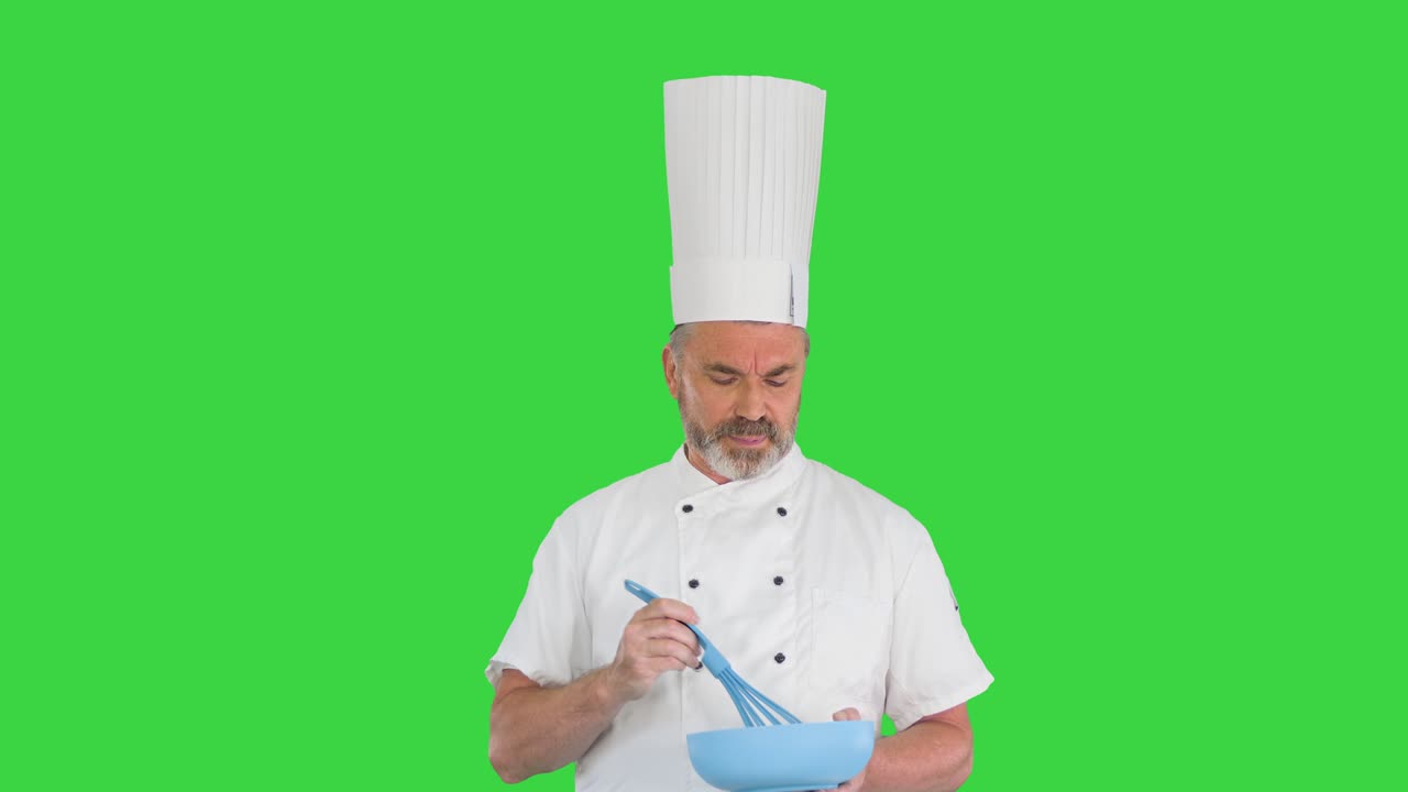 cocinero con un cuenco y un látigo preparando comida en una pantalla verde, clave de croma