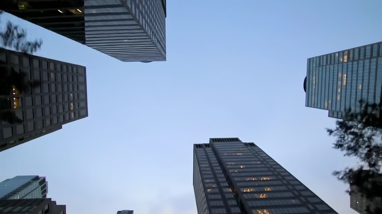 A Stunning Perspective of Tall Urban Buildings Against a Clear Sky Captured from the Ground, Emphasizing the Height and Architectural Design in a Cityscape Environment
