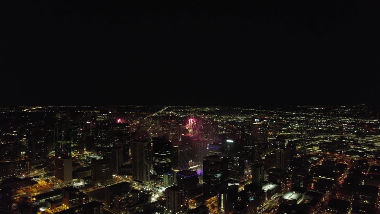 espectáculo de fuegos artificiales explotando en el centro de la ciudad de denver por la noche