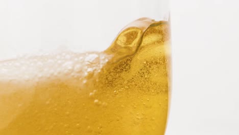 tiro macro en cámara lenta vertiendo cerveza dentro de un vaso medio lleno