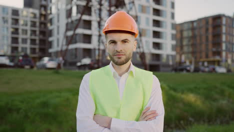 professional male engineer with hard hat and safety vest at construction site