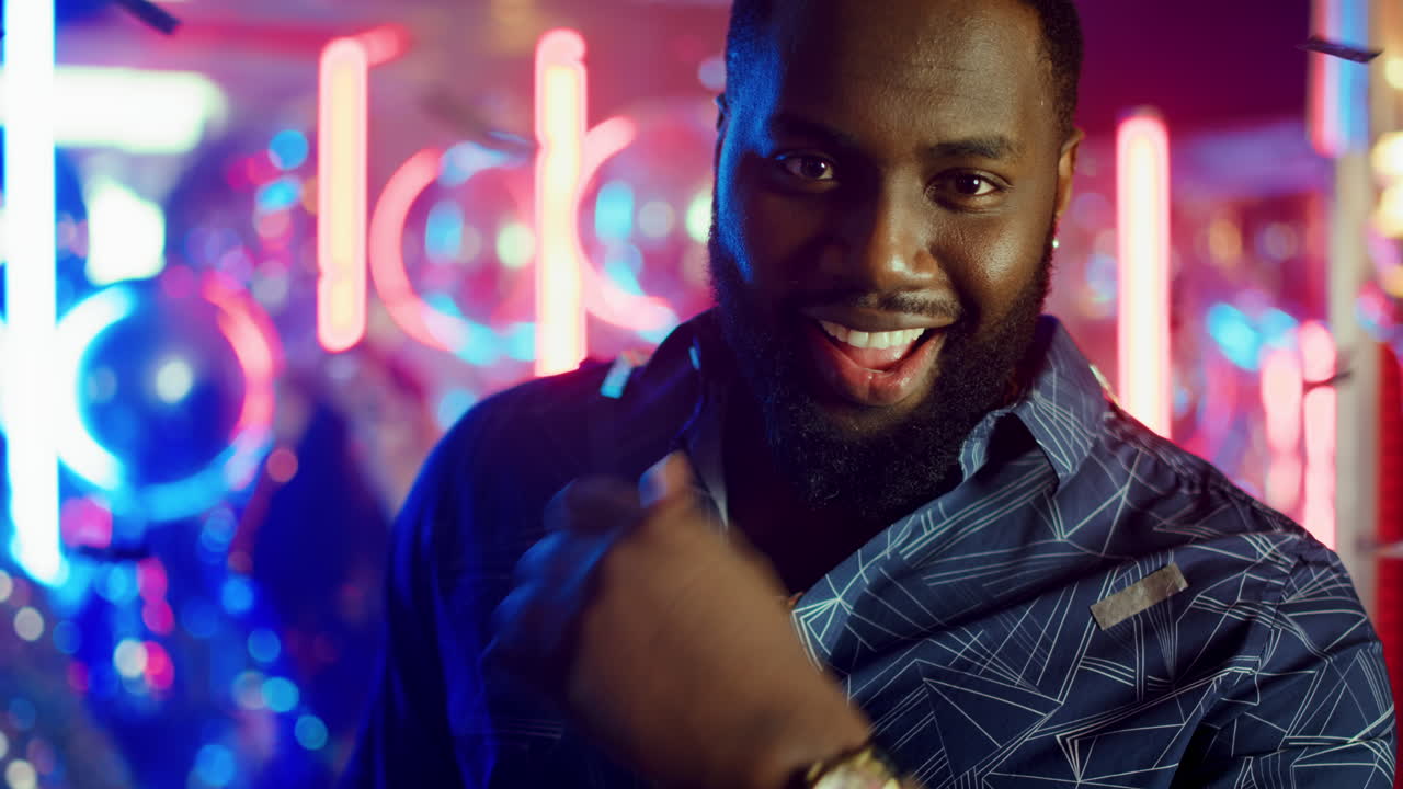 Affectionate man winking in club. Guy calling somebody with gesture at party