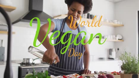 Animation-of-world-vegan-day-text-over-african-american-woman-pouring-oil-on-vegetable-salad