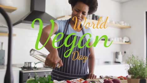 animation of world vegan day text over african american woman pouring oil on vegetable salad