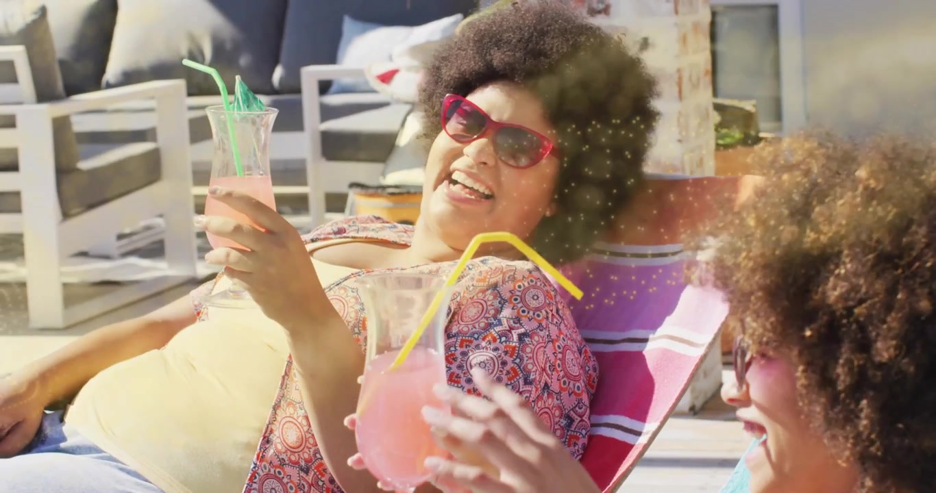 Due amici brindano con bevande rosa su un patio, con icone animate che illustrano il marketing.
