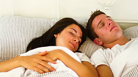 Couple-sleeping-in-bedroom