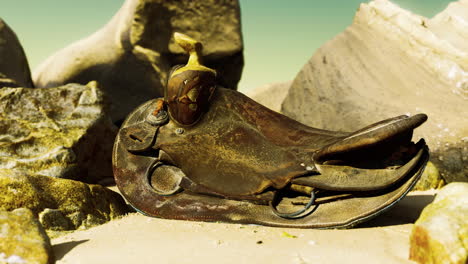 una silla de caballo muy vieja en la playa de arena