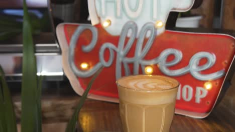 vintage signage of a coffee shop with warm glass of cafe latte - close up shot