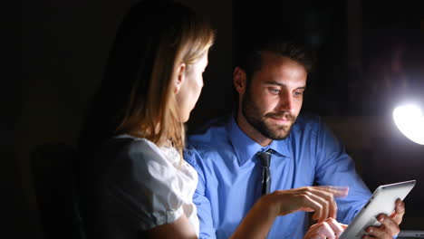 colleagues using a tablet at night