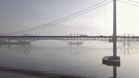 aerial footage of the old forth road bridge with the forth railway bridge in the background on a sunny day at south queensferry in west lothian, scotland