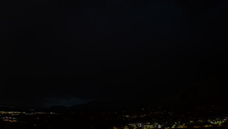 A-4k-aerial-shot-of-multiple-lightning-strikes-across-the-desert-sky-with-mountains-in-the-backdrop