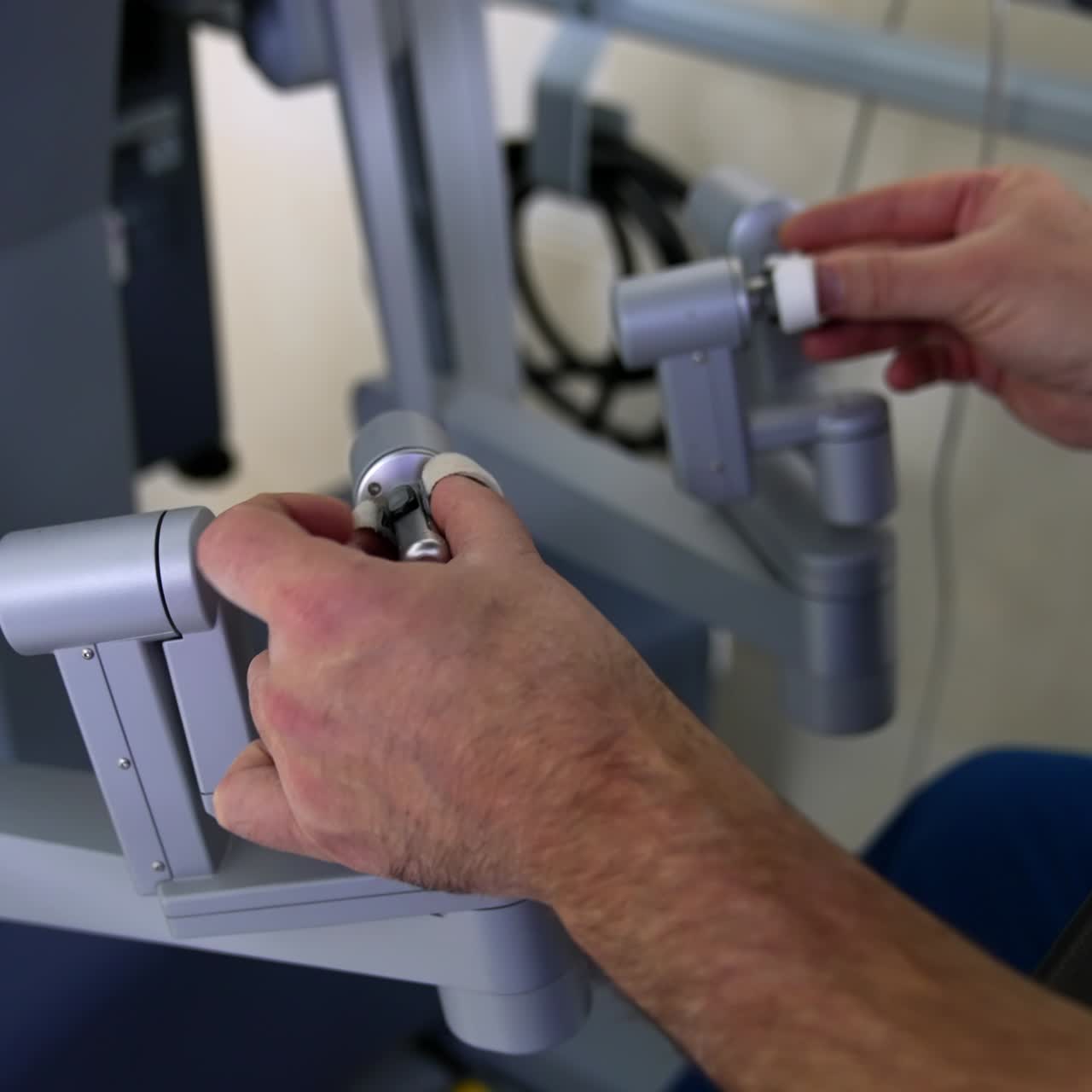 Managing the advanced equipment with the help of sensitive handles. Male doctor's hands move the rotating levers and operating the machine