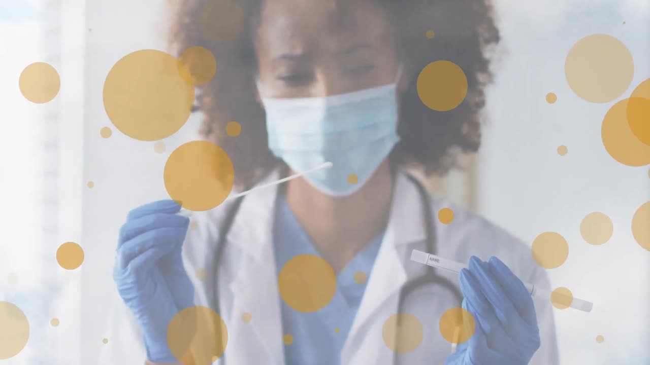 manchas anaranjadas contra una mujer médica afroamericana con máscara facial sosteniendo un hisopo para la prueba de covid