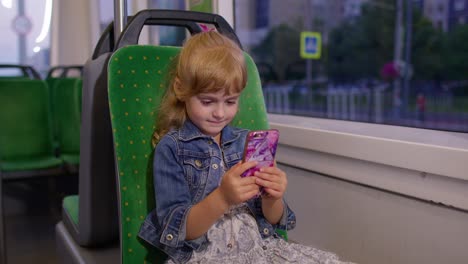 Girl-playing-on-smartphone,-chatting,-texting,-browsing-social-media-while-traveling-by-tram-to-city