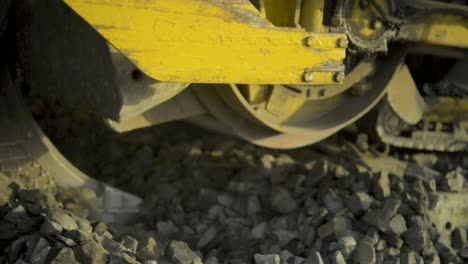 primer plano de una máquina amarilla desmantelando las vías del tren