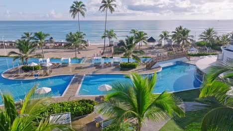 Complejo-Vacacional-Paraíso-Caribeño,-Piscina,-Playa-De-Arena-Y-Océano,-Drone