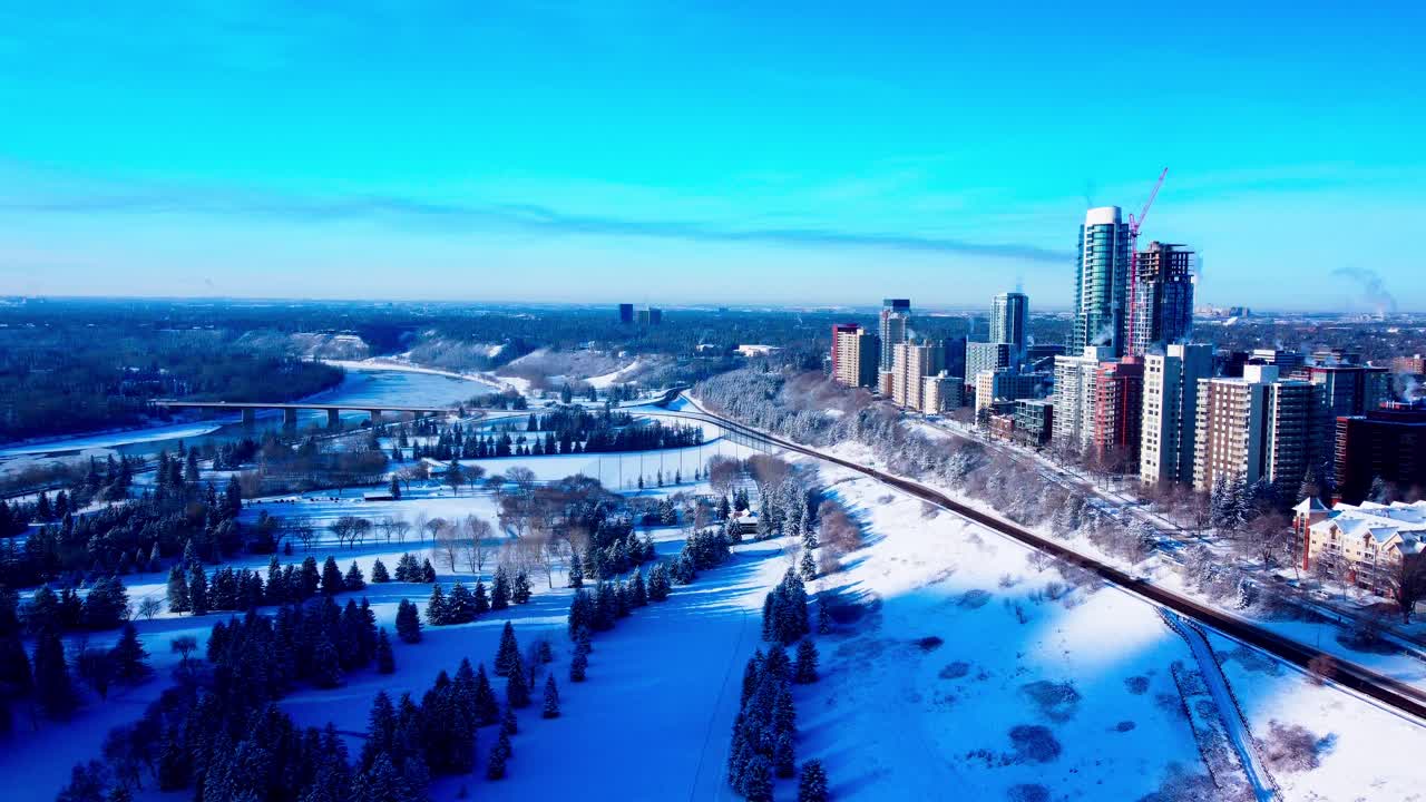 sobrevuelo aéreo paralelo de invierno los rascacielos residenciales más exclusivos de edmonton, canadá, desde 116 a 121 st nw en 100 ave nw con vistas al parque victoria cubierto de nieve esquí de fondo parque público