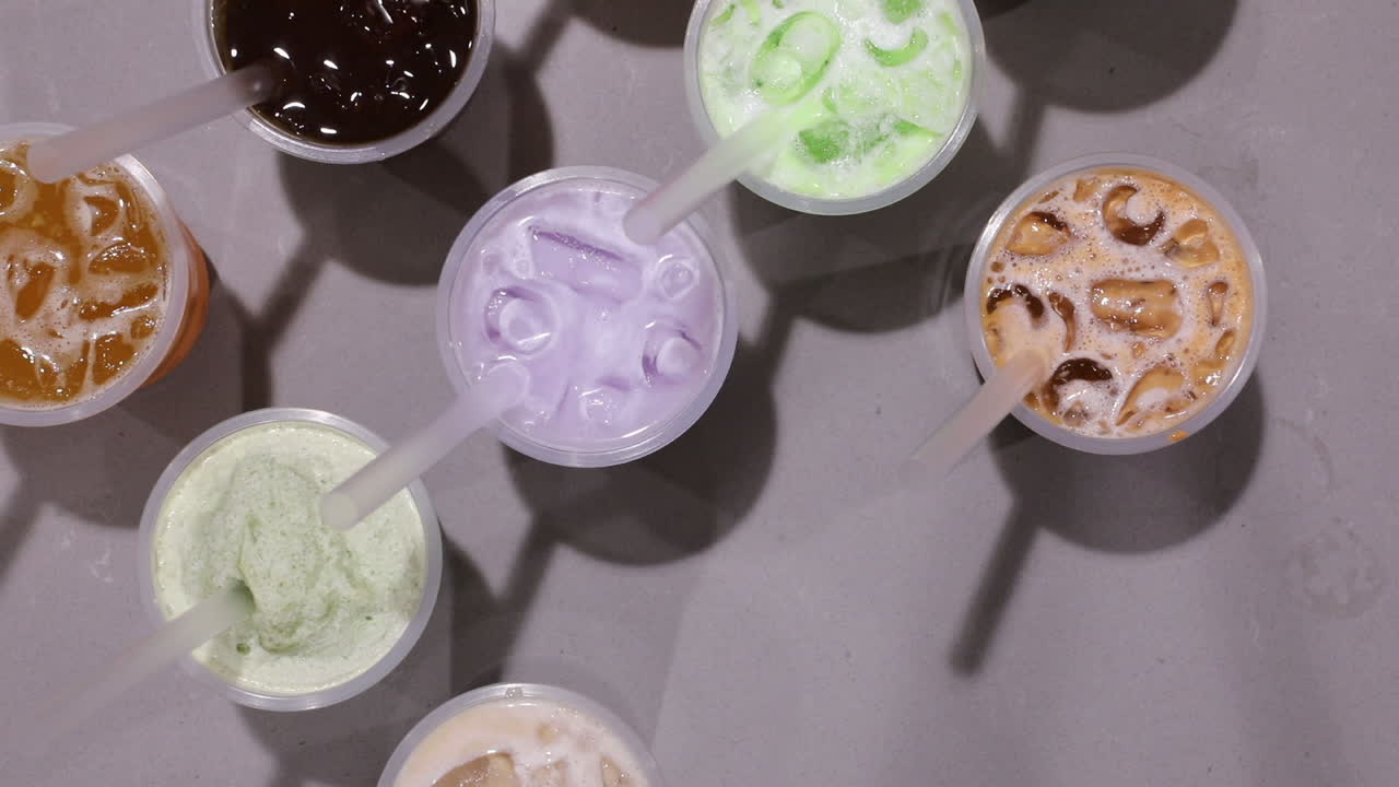 타로 우유 음료 그룹에서 차가운 용과 주스 음료를 집어드는 남성 손