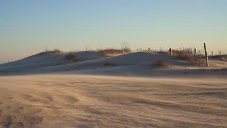 Fuertes-Vientos-Entierran-Una-Valla-Bajo-Dunas-De-Arena-Blanca-Durante-Una-Tormenta-De-Arena-En-El-Día