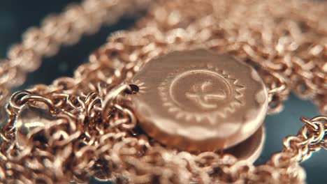 A-detailed-macro-shot-of-a-golden-medallion-necklace,-flying-bird-in-the-middle-of-the-sun-symbol,-on-a-rotating-stand,-mirror-reflection,-studio-lighting,-4K-video