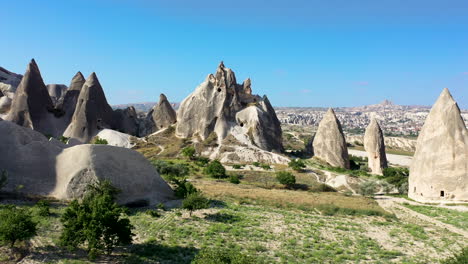 Epic-cinematic-revealing-drone-shot-of-a-lone-man-standing-in-the-middle-of-the-fairy-chimneys-in-Cappadocia,-Turkey
