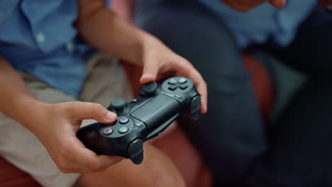 manos de niño jugando con un gamepad. niño masculino usando un joystick para un juego de computadora