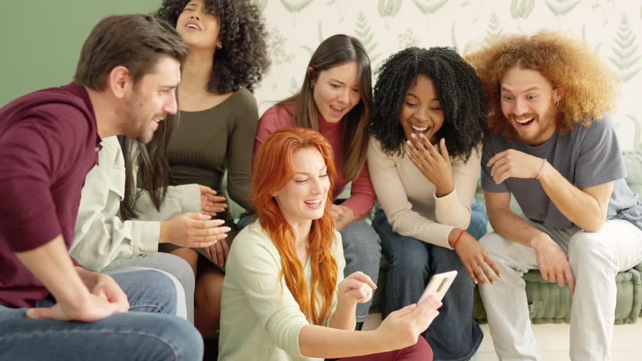 Friends looking at a mobile and laughing at one video