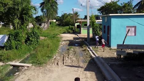 Drohnenaufnahme-Von-Spielenden-Kindern-In-Einer-Ländlichen-Straße-Von-Higuey,-Provinz-La-Altagracia