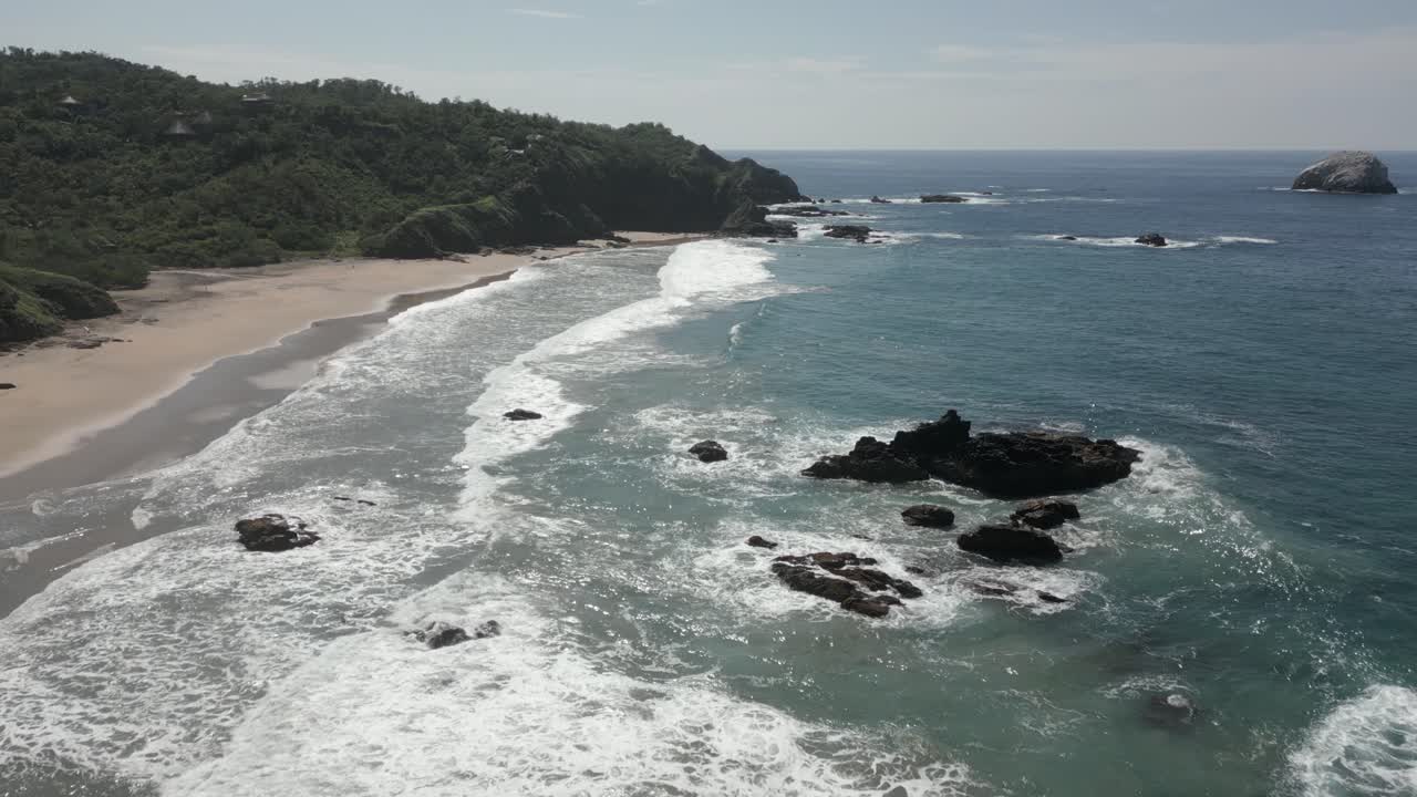Spiaggia sabbiosa e rocce frastagliate al largo sulla riva del mare, costa oceanica blu