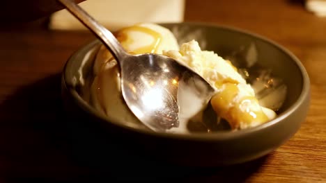 persona comiendo helado con salsa de caramelo
