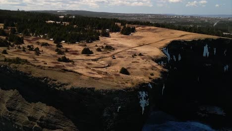 Toma-Giratoria-De-Un-Dron-De-Un-Vehículo-Todo-Terreno-Conduciendo-A-Lo-Largo-Del-Borde-De-Acantilados-De-300-Pies.