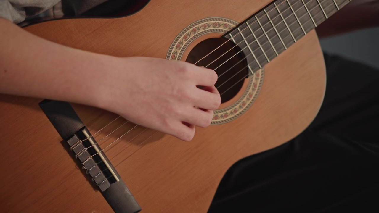 Closeup fingerpicking at soundhole, aspiring performer practices classical arpeggios with fingertip precision, subtle nail technique and warm resonance, rehearsal for recital in private conservatory
