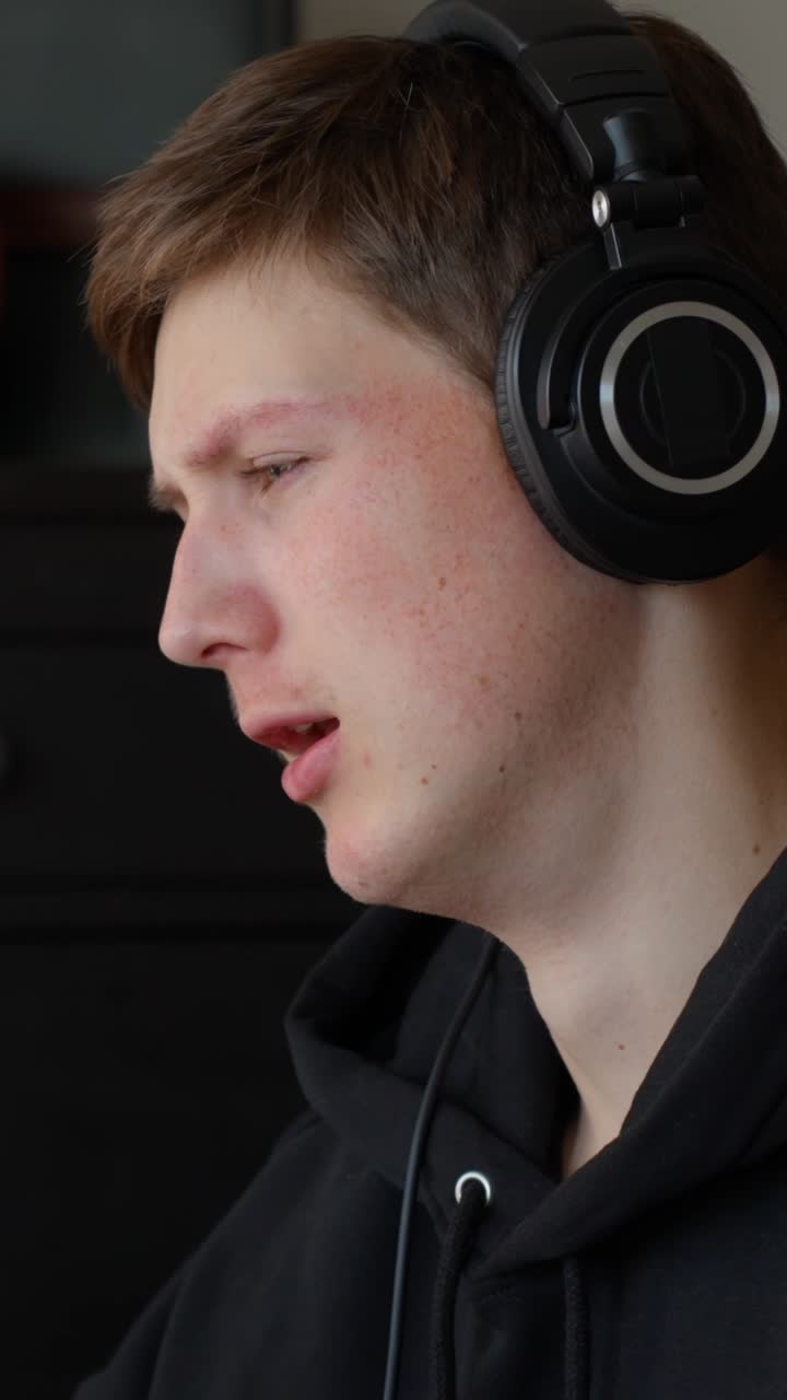 Young person with headphones appearing stressed indoors