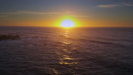 arcing drone shot of sunset over the sea.