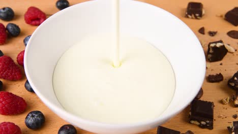 tiro de yogur que se vierte en un tazón