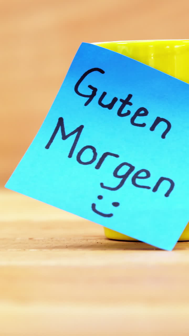Kaffekopp med et tysk «god morgen»-klistremerke