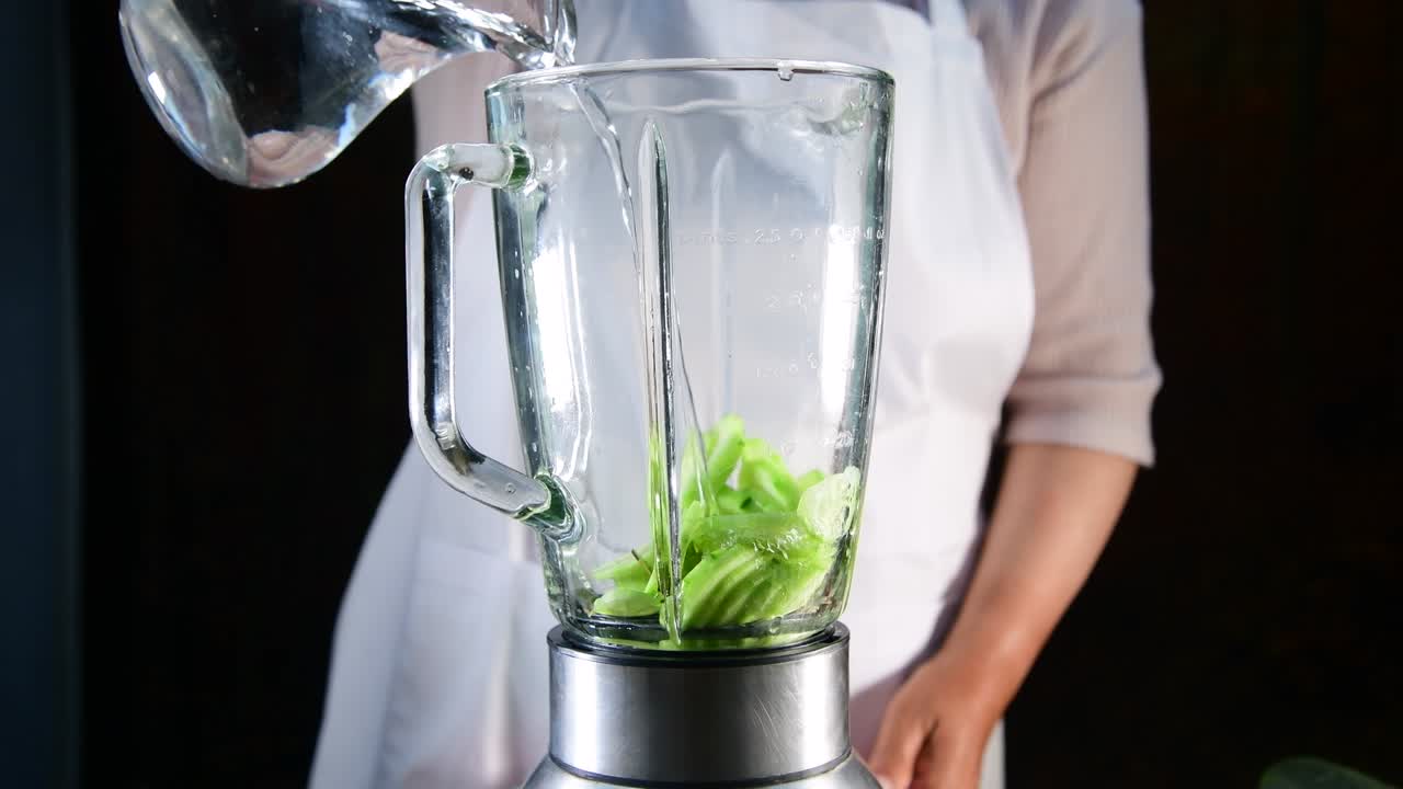 una mujer haciendo jugo de pepino