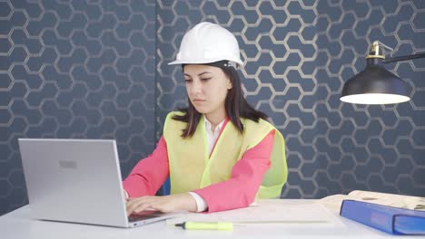 Woman-engineer-holding-laptop-laughing-at-camera.