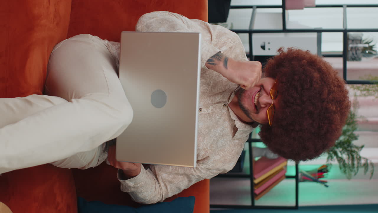 Amazed young man use laptop computer, receive good news message, shocked by victory, celebrate win