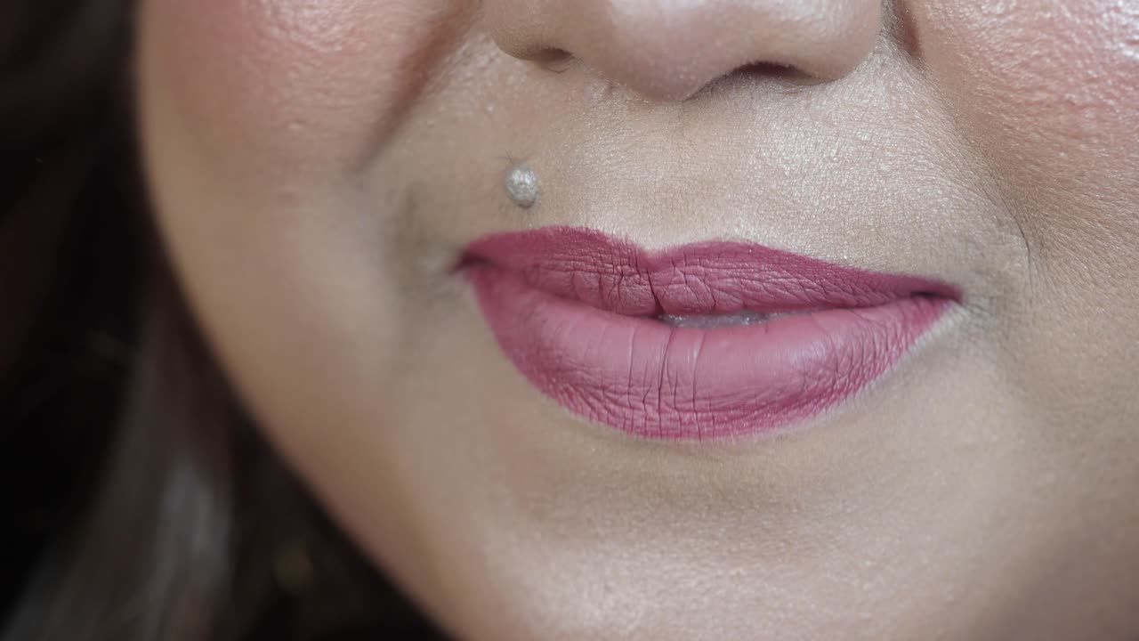 Close-up of a Woman's Lips with Pink Lipstick and Philtrum Piercing